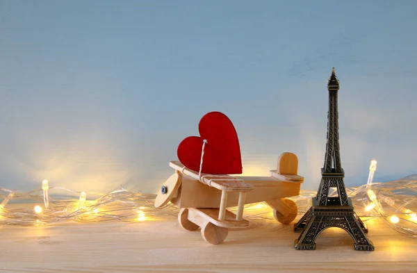 Houten vliegtuig met hart naast de Eiffeltoren — Stockfoto
