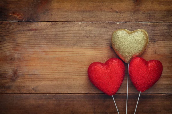 Corazones de purpurina roja sobre fondo de madera —  Fotos de Stock