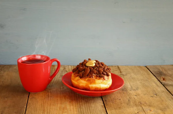 Пончик рядом с чашкой кофе — стоковое фото