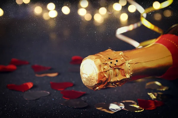 Champagneflaska och festliga ljus — Stockfoto
