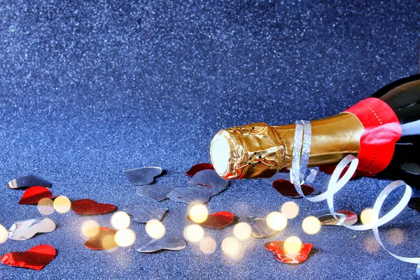 Garrafa de champanhe e luzes festivas — Fotografia de Stock