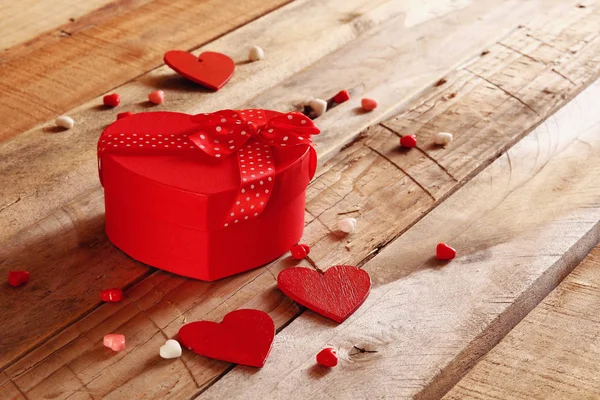 Corações vermelhos e caixa de presente na mesa de madeira — Fotografia de Stock