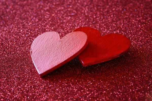 Corações vermelhos de madeira no fundo brilhante vermelho — Fotografia de Stock