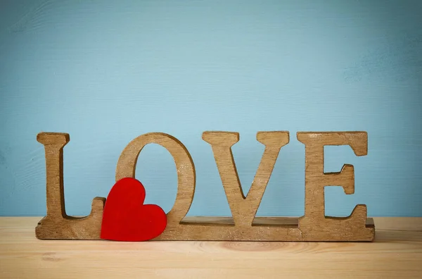 Woord liefde van houten letters en rood hart — Stockfoto