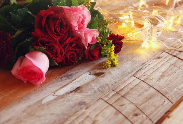 Bukett rosor bredvid guld garland lights — Stockfoto
