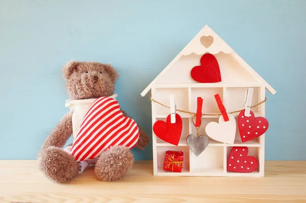 Houten huis met veel hartjes en schattige teddybeer — Stockfoto