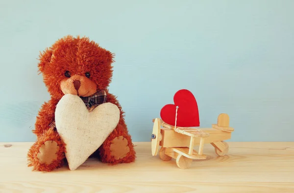 Cute teddy bear sitting and holding a heart — Stock Photo, Image