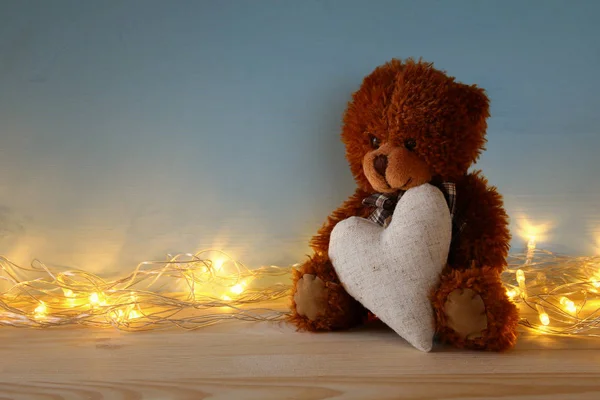 Niedlicher Teddybär sitzt und hält ein Herz — Stockfoto