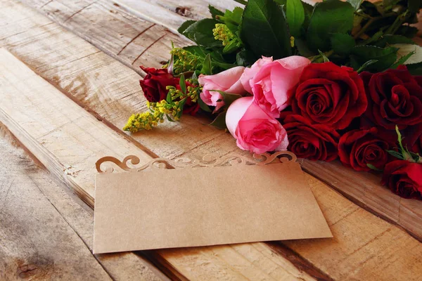 Hermoso ramo de rosas al lado de la carta —  Fotos de Stock