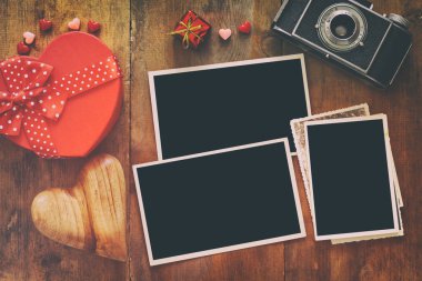 eski fotoğraf makinesi ve kalpleri yanındaki boş fotoğraf çerçeveleri