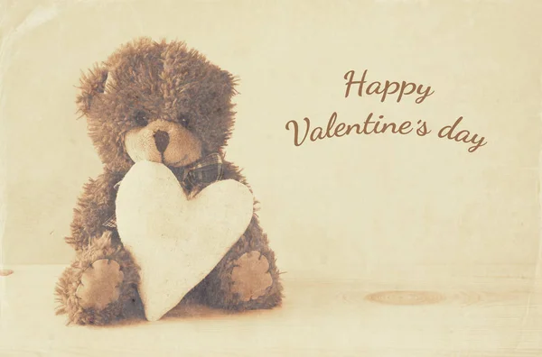 Cute teddy bear sitting and holding a heart — Stock Photo, Image