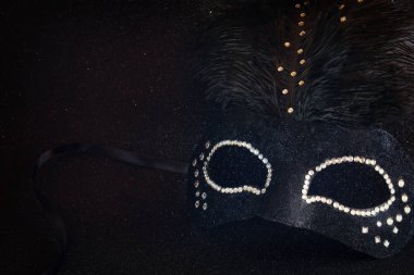black venetian mask on glitter background clipart