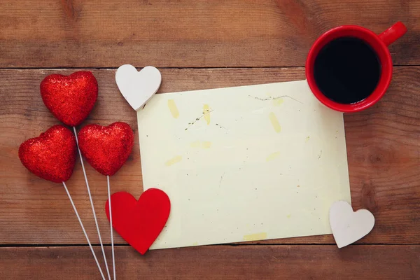 Bir kahve ahşap arka plan üzerinde kırmızı Kalpler ve — Stok fotoğraf
