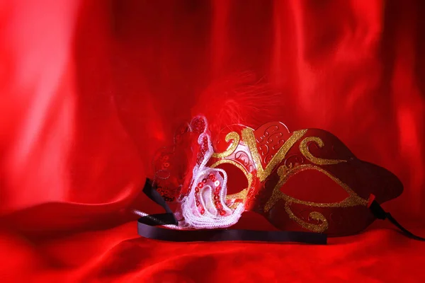 Elegante venezianische Maske auf rotem Seidenhintergrund — Stockfoto