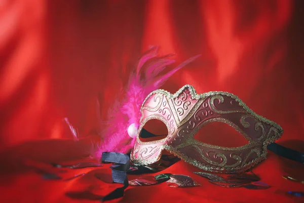 Eleganckiej weneckiej masce na czerwonym tle jedwabiu — Zdjęcie stockowe