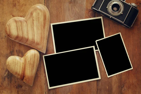 Άδειο κορνίζες δίπλα στην παλιά φωτογραφική μηχανή και καρδιές — Φωτογραφία Αρχείου