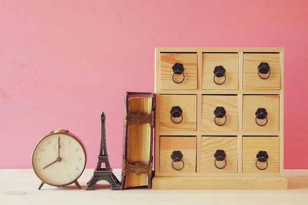 Cómoda antigua con cajones al lado del libro viejo y la torre eiffel — Foto de Stock