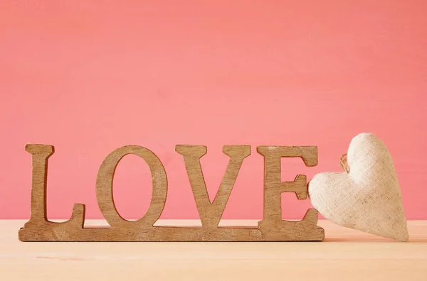 Slovo láska z dřevěných písmen a srdce — Stock fotografie