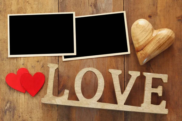 Порожні фоторамки наступне слово "LOVE" з дерев'яних літер — стокове фото