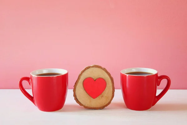 Ξύλινη καρδιά δίπλα σε φλιτζάνια καφέ — Φωτογραφία Αρχείου