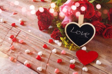 Kırmızı kalp ve gül ahşap masa üzerinde