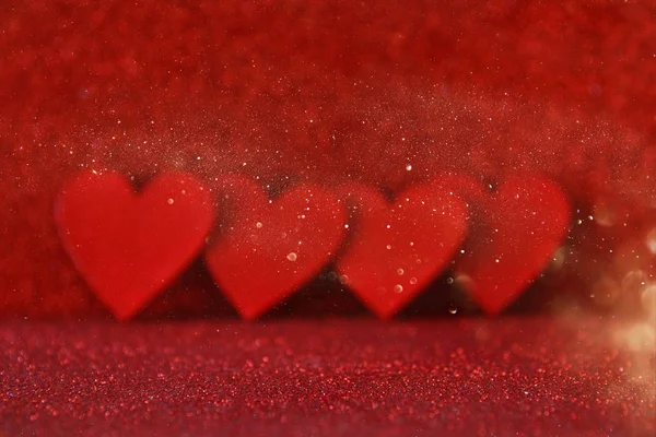 Houten rode harten op rode glanzende achtergrond — Stockfoto