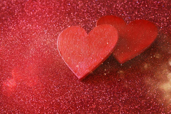 Corações vermelhos de madeira no fundo brilhante vermelho — Fotografia de Stock