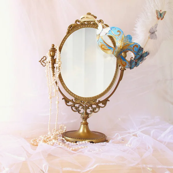 Blaue venezianische Maske neben altem ovalen Spiegel — Stockfoto