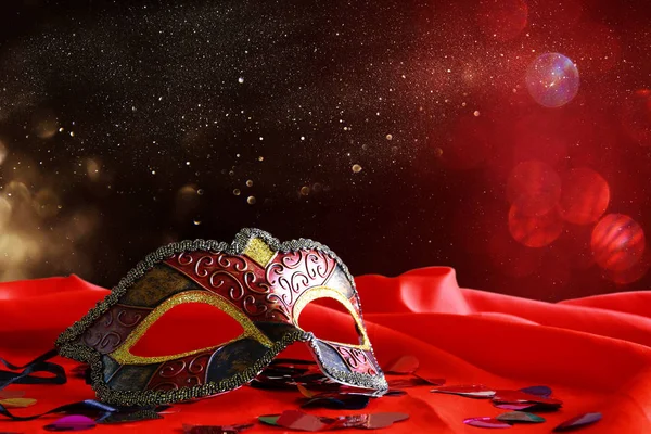 Máscara veneziana elegante no fundo de seda vermelha — Fotografia de Stock