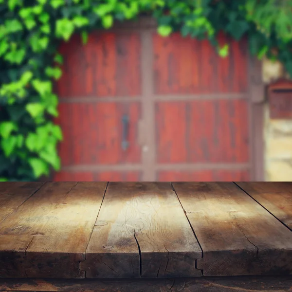 Mesa vazia na frente da porta de madeira antiga desfocada — Fotografia de Stock