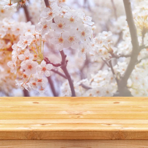 Деревянный стол перед белым вишневым деревом — стоковое фото