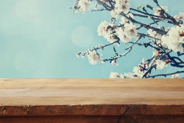Mesa de madeira na frente da árvore de cereja primavera — Fotografia de Stock