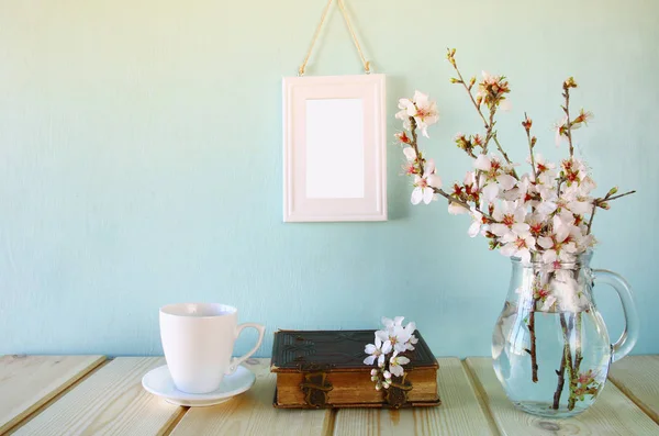 Стара книга, чашка кави біля весняних білих квітів — стокове фото