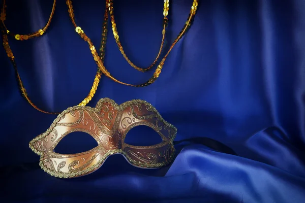 Gouden Venetiaanse masker op blauwe zijde achtergrond — Stockfoto