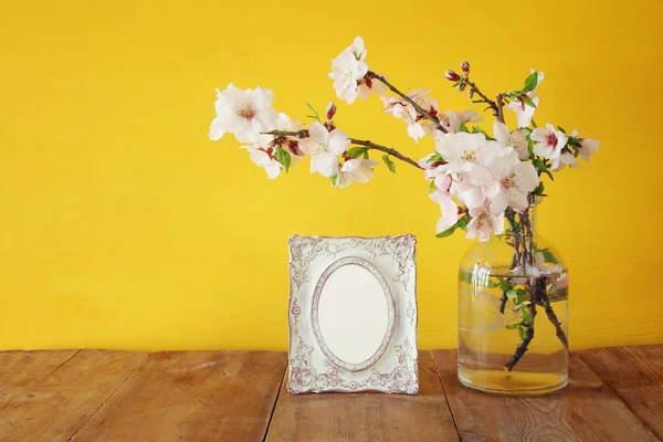Marco de fotos en blanco vintage junto a flores blancas de primavera — Foto de Stock