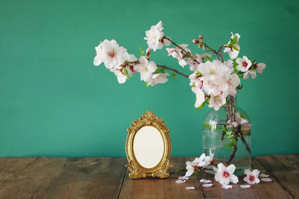 Vintage blank photo frame next to spring white flowers — Stock Photo, Image