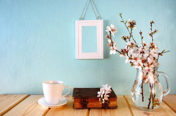 Oud boek, kopje koffie naast witte Lentebloemen — Stockfoto