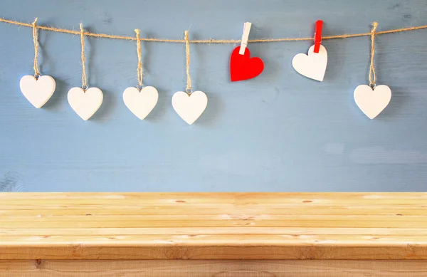 Hearts hanging in front of wooden background — Stock Photo, Image