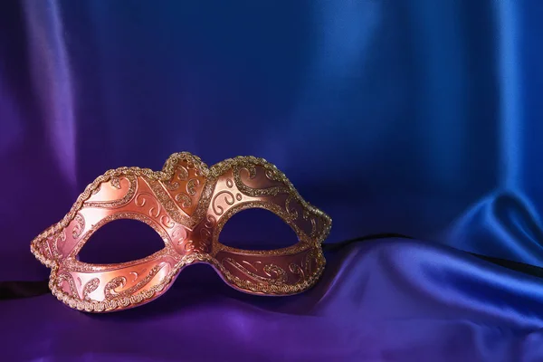 Gold venetian mask on blue silk background — Stock Photo, Image