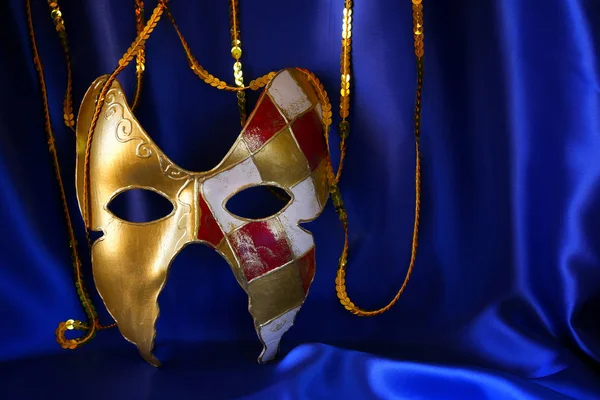 Gouden Venetiaanse masker op blauwe zijde achtergrond — Stockfoto