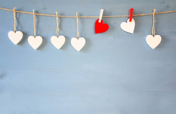 Hearts hanging in front of wooden background — Stock Photo, Image