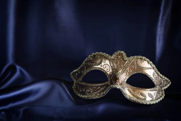 Gold venetian mask on blue silk background — Stock Photo, Image