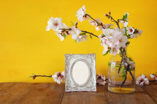 Marco de fotos en blanco vintage junto a flores blancas de primavera — Foto de Stock