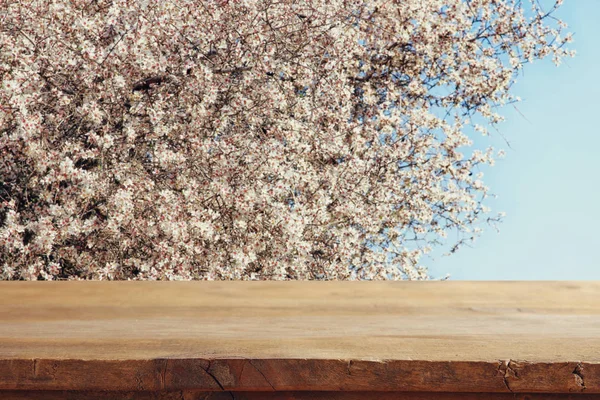 Деревянный стол перед весенним цветущим сакурой — стоковое фото