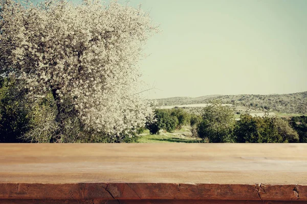Деревянный стол перед весенним цветущим сакурой — стоковое фото
