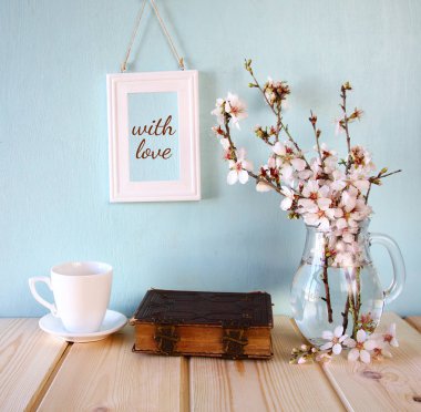 eski kitap, bahar beyaz çiçekleri yanında kahve