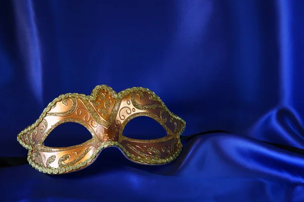 Gouden Venetiaanse masker op blauwe zijde achtergrond — Stockfoto