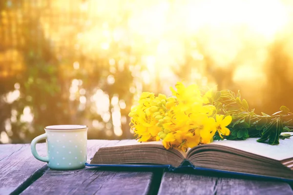 Régi könyv, csésze kávé mellett mező virágok — Stock Fotó