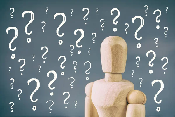 Wooden dummy with question marks — Stock Photo, Image