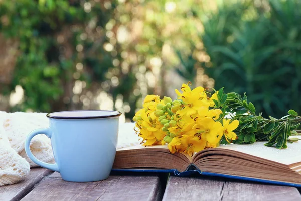 Oud boek, kopje koffie naast veld bloemen — Stockfoto